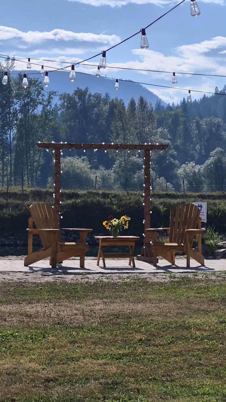 Adirondack chairs under the string-lit arbor at Eden Farm